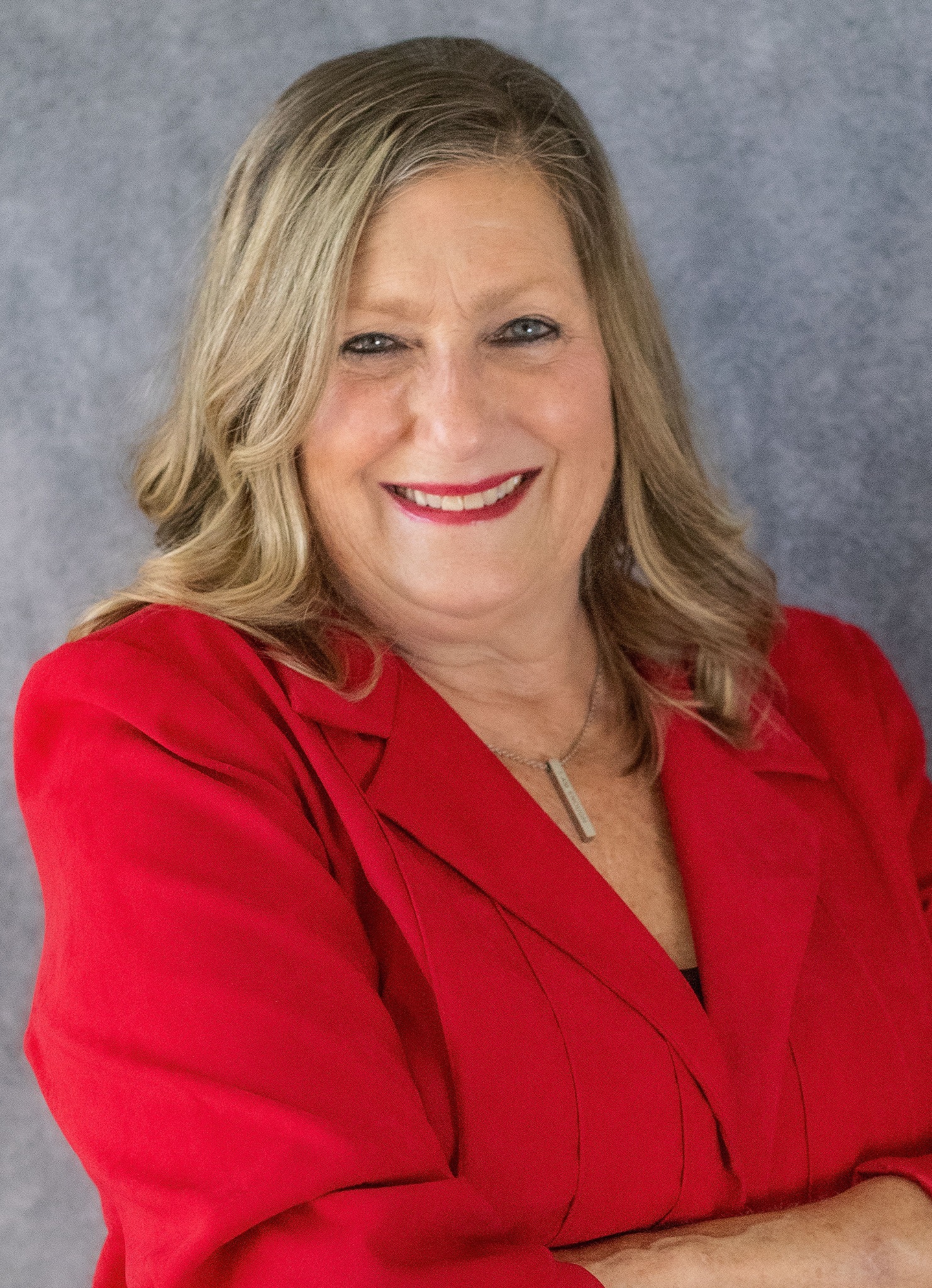 Val Romero smiling in a red jacket